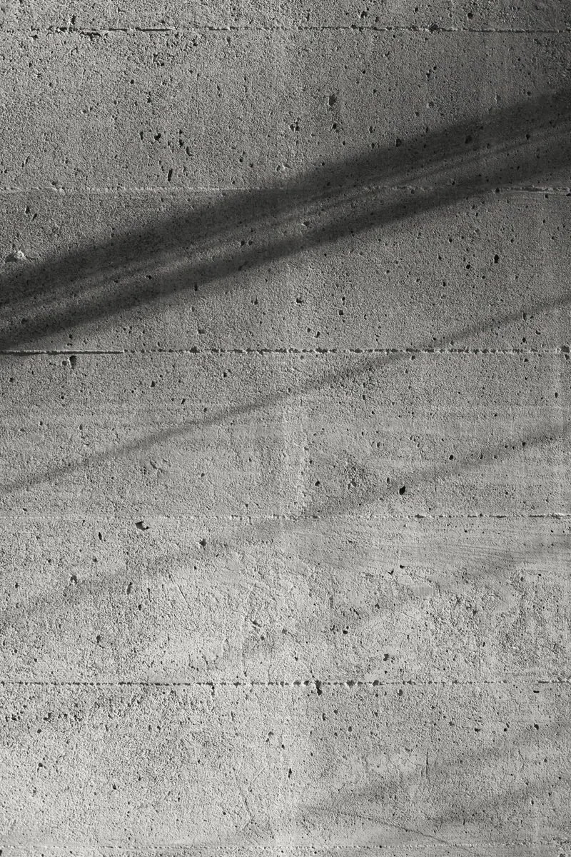 Superfície de concreto aparente com uma sombra diagonal.